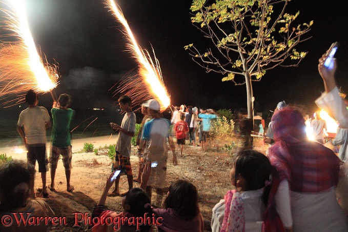 People letting off fireworks by hand for end of Ramadan celebrations.  Gili Islands, Lombok, Indonesia