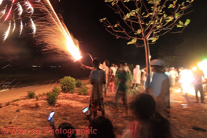 People letting off fireworks by hand for end of Ramadan celebrations.  Gili Islands, Lombok, Indonesia