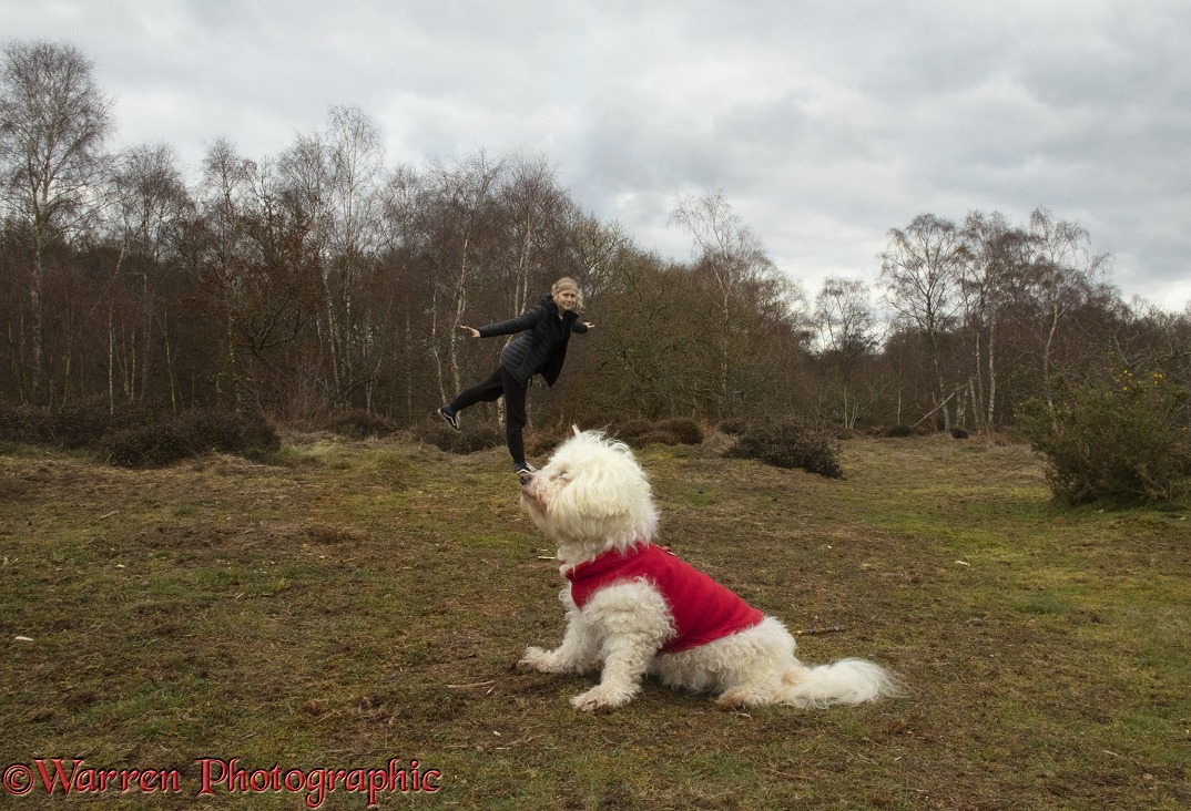 Forced perspective photo of a young lady appearing to stand on a dog's nose