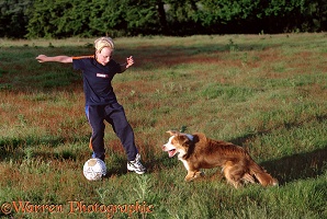 Boy playing football with Border Collie