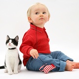 Toddler with black-and-white kitten and catnip mouse