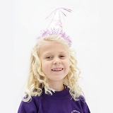 Little girl (5) with birthday party hat on