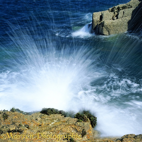 Wave splashing against a granite boulder.  Lundy Island, England