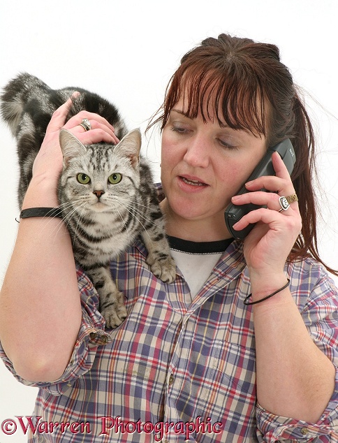 Woman phoning with cat on her shoulder, white background