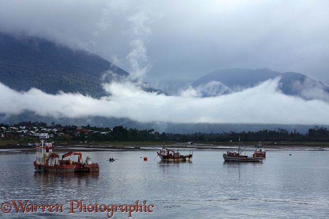 Boats in front of Mountains and low clouds.  Chile