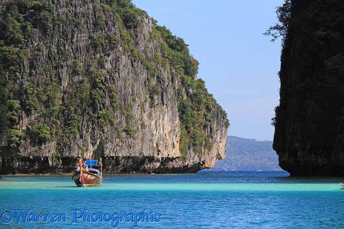 Long-tail boat and limestone cliffs.  Koh Phi Phi, Thailand