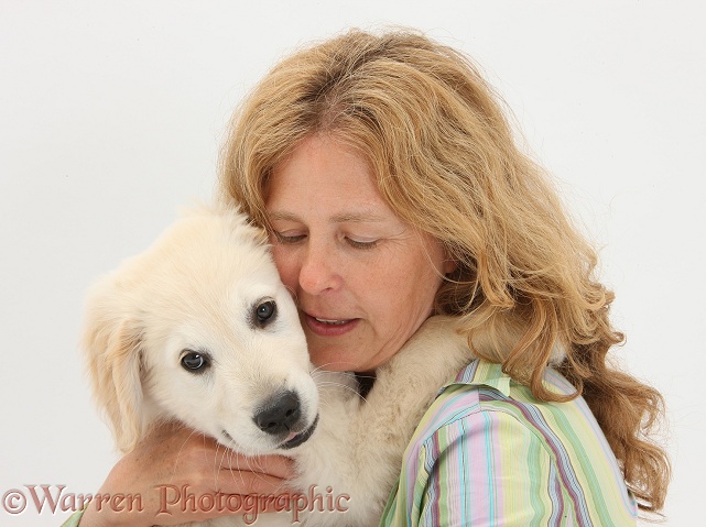 Miriam cuddling Golden Retriever dog pup, Oscar, 3 months old, white background