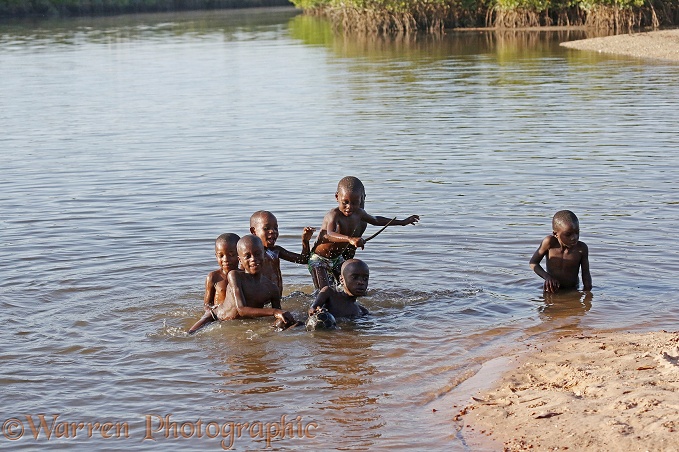 African boys playing in a distributary of the River Gambia