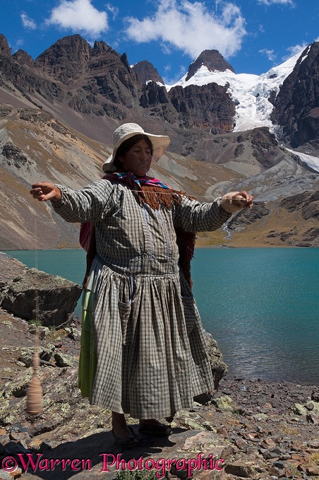 Bolivian woman spinning alpaca wool by hand.  Ch'iyar Quta Lake, Bolivia