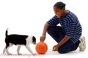 Boy and puppy with a ball