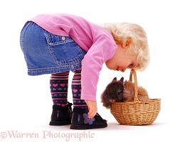 Little girl with rabbits in a basket