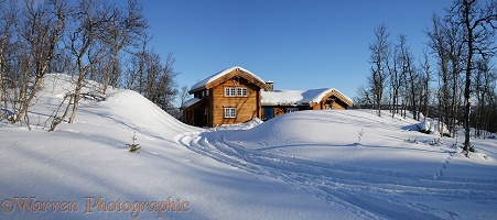 Wooden house with deep snow