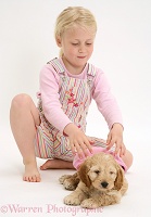 Girl putting a hat on a puppy