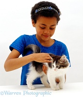 Girl stroking Tabby-and-white kitten
