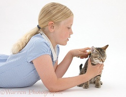 Girl grooming a tabby kitten with a soft brush