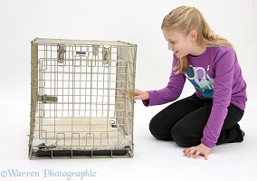 Girl looking into a dog carry crate