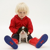 Little girl with Cavalier pup and welly boots