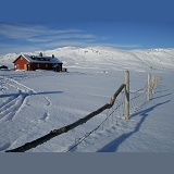 Alpine hut and fence with snow