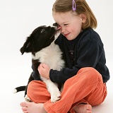 Child being licked by a puppy