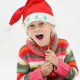 Little girl laughing and wearing a Santa hat