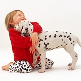 Girl hugging Dalmatian puppy