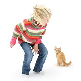 Girl scaring a ginger kitten