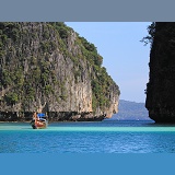 Long-tail boat and limestone cliffs