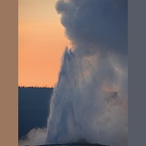 Old Faithful geyser at sunset