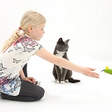 Girl throwing a toy mouse for a cat